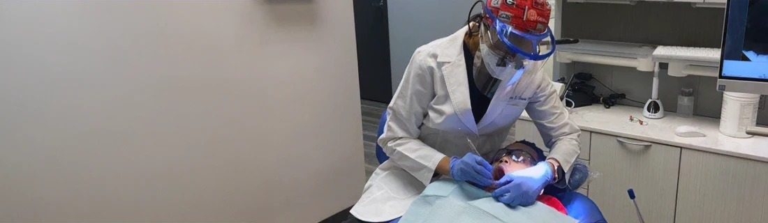 Dentist Lawrenceville GA Root Canal Focused a photo of dentist Anna Duval performing a procedure on a dental patient